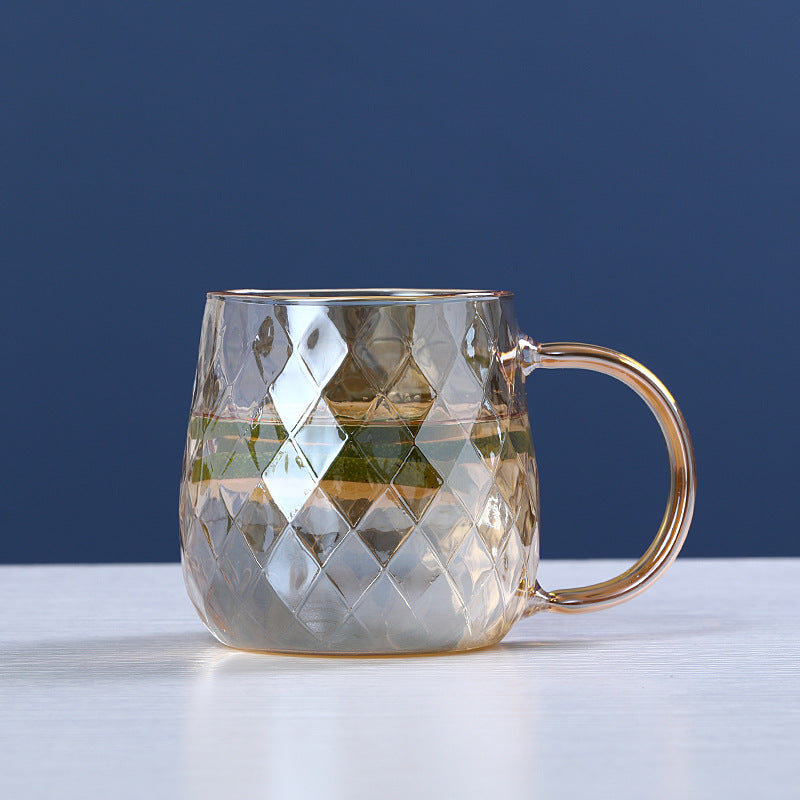 Glass mug with diamond pattern on a white surface and blue background