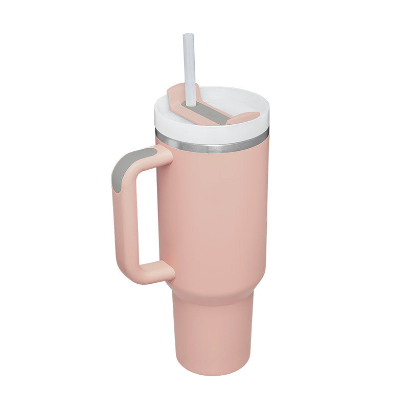 Pink tumbler with a handle and straw on a white background